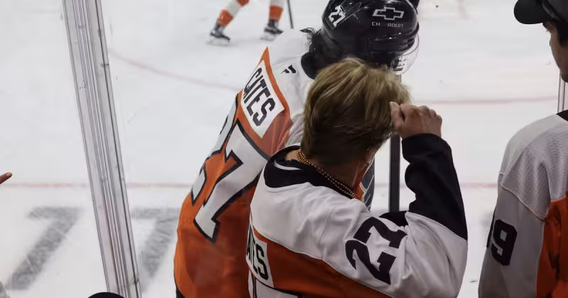 Noah Cates and Flyers fan Kathleen Shive share a warmup ritual at home games